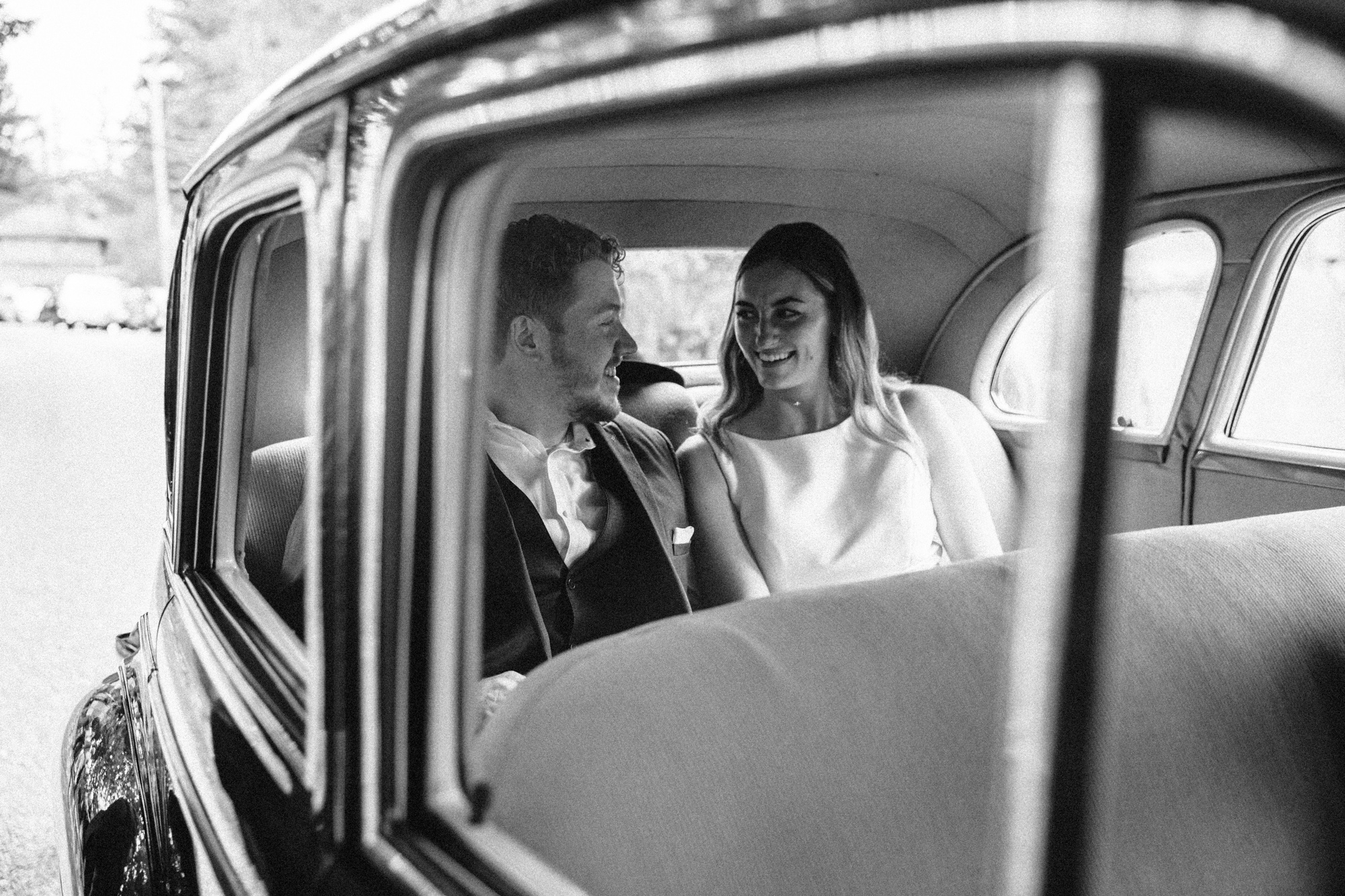A wedding couple in a getaway car