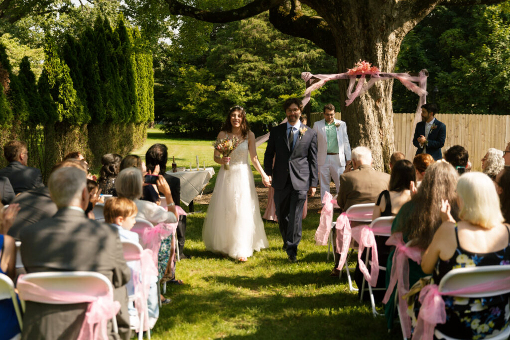 Bride and groom walk back down the aisle smiling after their Bella Tori at the Mansion ceremony