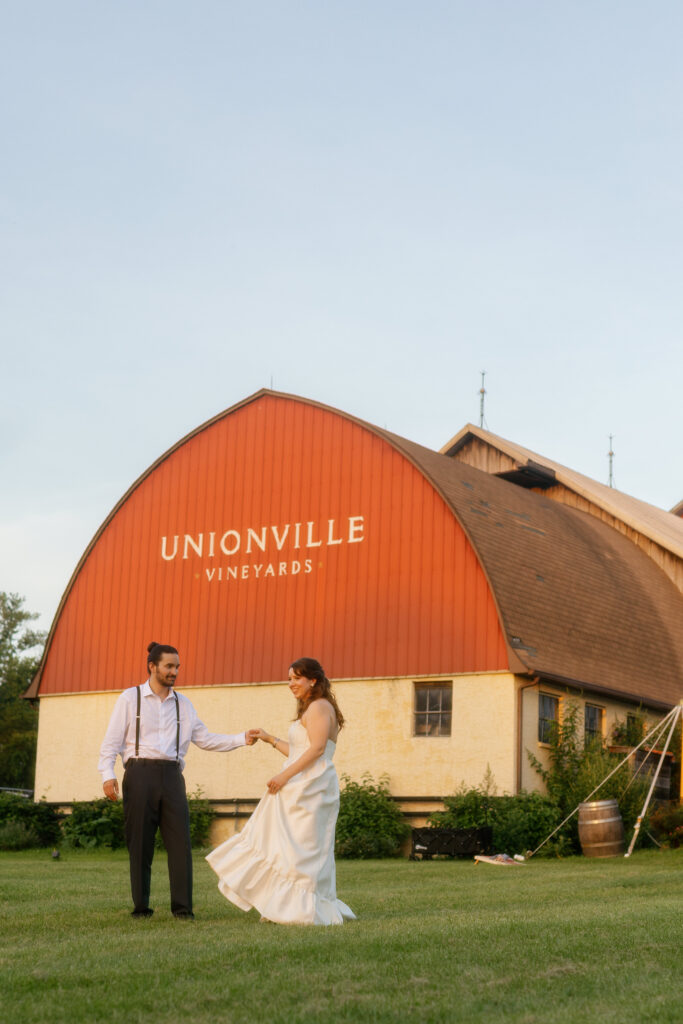 Bride and groom in front of rustic barn at Unionville Vineyards