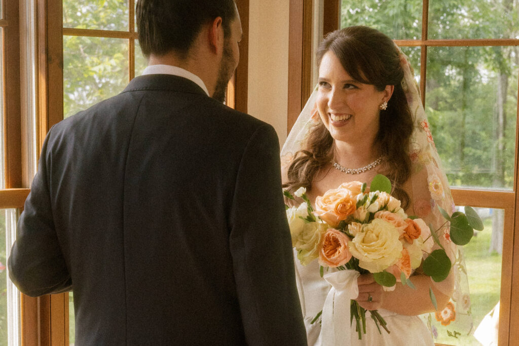 Cinematic wedding photography moment during first look in sunroom