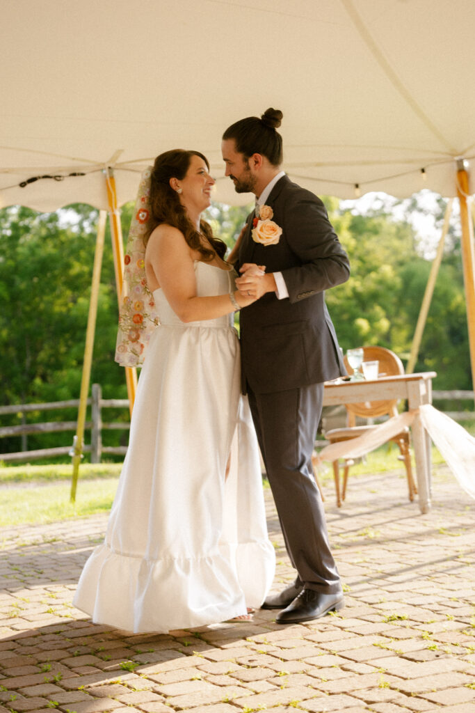 Bride and groom’s first dance under tented patio at vineyard wedding