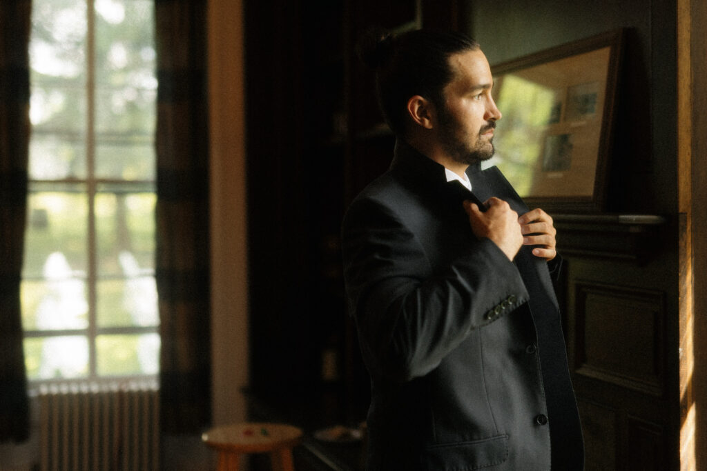 Groom getting ready inside farmhouse at Unionville Vineyards