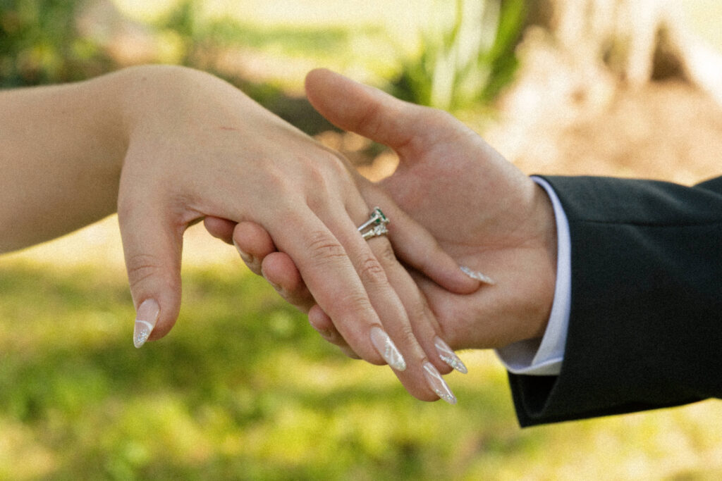 Groom holding bride’s hand during romantic candid moment