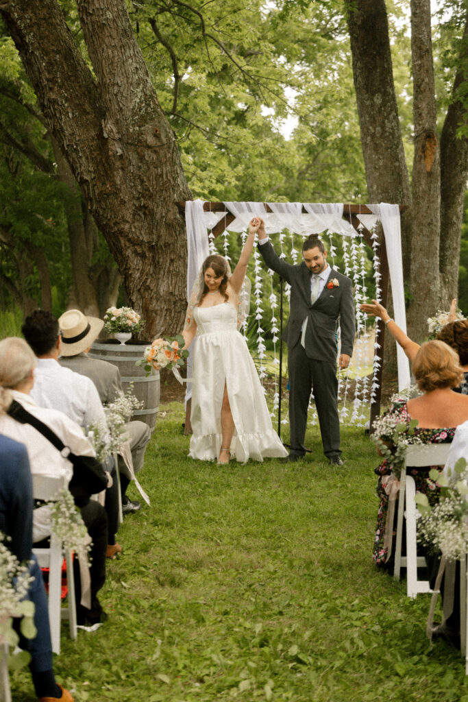 Just-married couple celebrating while walking back up the aisle